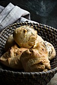 Poppyseed rolls in a grey bread basket with a fabric napkin