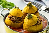 Yellow squash filled with minced meat and tomato sauce and cutlery