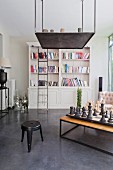 Large chess set on table below suspended, decorative metal element