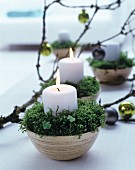 Arrangement of candles, moss and branch