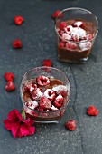 Banana and chocolate mousse with raspberries in glasses