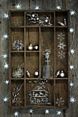 Christmas decorations in old wooden display case surrounded by star-shaped fairy lights