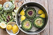 Artichokes with water, lemon and garlic in a pot