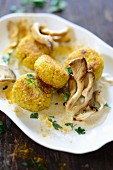 Golden millet cakes with oyster mushrooms and a creamy sauce