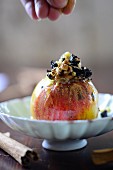 A baked apple filled with dried plums and walnuts