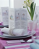 Pictures on menu cards and linen napkins with elegant napkin rings on festively set table