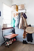 Folding bench and various baskets in hallway painted white and pale grey