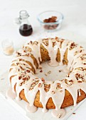 An iced ring shaped sponge cake with nuts and roasted coconut