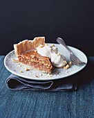 A slice of nut and caramel pie with cream
