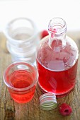 Raspberry syrup in a bottle and a glass