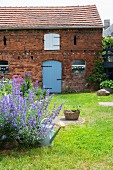 Old brick house in cottage garden with green lawn