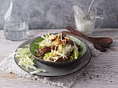 Iceberg lettuce with fried minced meat and bacon