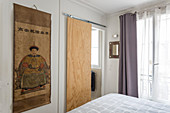 Plywood sliding door next to Chinese wall hanging