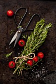 Freshly cut rosemary with cherry tomatoes, sea salt and herb scissors