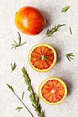 Blood oranges, whole and halved, with rosemary