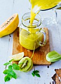 A yellow smoothie with exotic fruit, cucumber and herbs