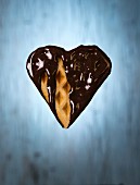 A heart-shaped vegan waffle dipped in chocolate