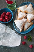 Beignets with icing sugar and raspberries