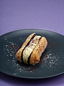 A sponge finger filled with mascarpone and chocolate sauce