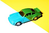Cyan coloured toy car under yellow light