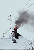 Burning chimney on snowy house