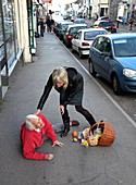Elderly woman being helped after falling