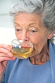 Elderly woman drinking herbal tea