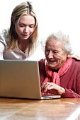 Elderly lady learning to use a laptop