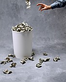 Throwing US currency into a bin