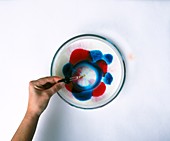 Hand dropping detergent in dish