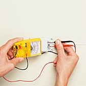 Hand inserting black and red wires