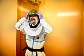 Scientist putting on protective clothing