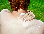 Applying suntan lotion to pale skin