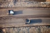 Massive dump trucks loaded with tar sand