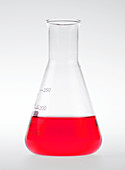 Conical flask holding red liquid