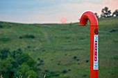 Natural gas pipeline marker at sunset