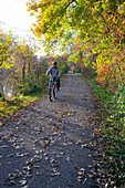 Cyclist in parkland in autumn