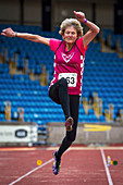 Senior British female athlete mid-air