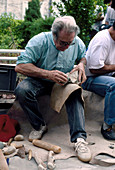 Archaeologist knapping flint stone tool