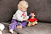 Baby uses an inhalation mask on her doll