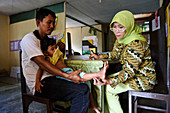 Doctor examining a boy,Indonesia
