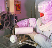 A glaciologist using a saw to cut ice core