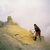 Volcanologist sampling sulphur deposit on volcano