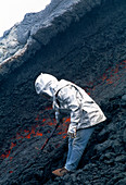 Volcanologist by Mount Etna lava flow