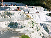 People bathing in mineral terraces