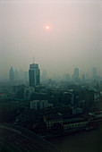 Air pollution over a city discolouring the Sun