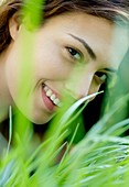 Woman smiling through grass