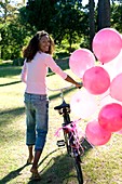 Woman with a bicycle and balloons