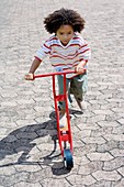 Boy riding a toy scooter