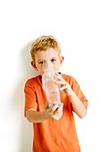 Boy using an asthma spacer